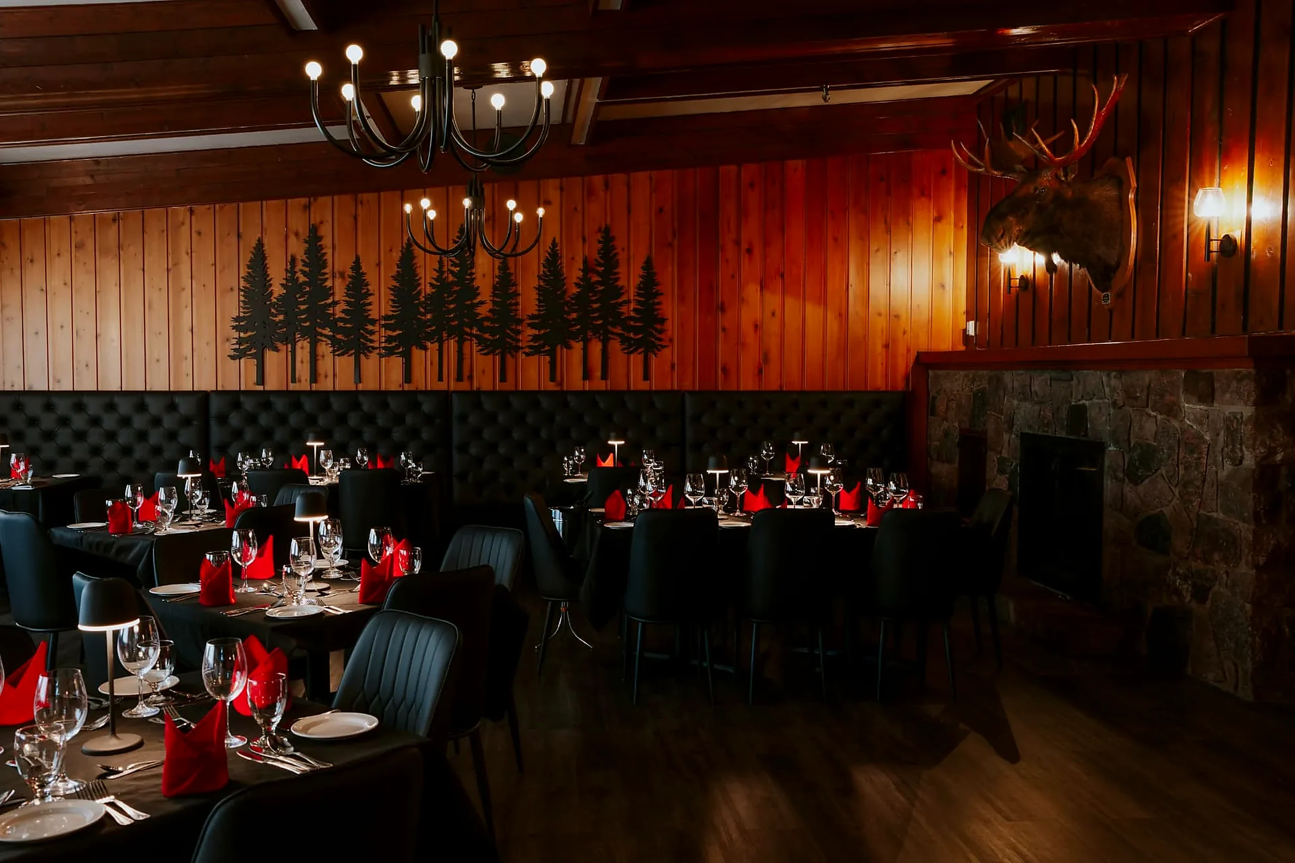 The Frozen Rooster dining room in Wabush with fireplace, chandeliers and tables set for supper