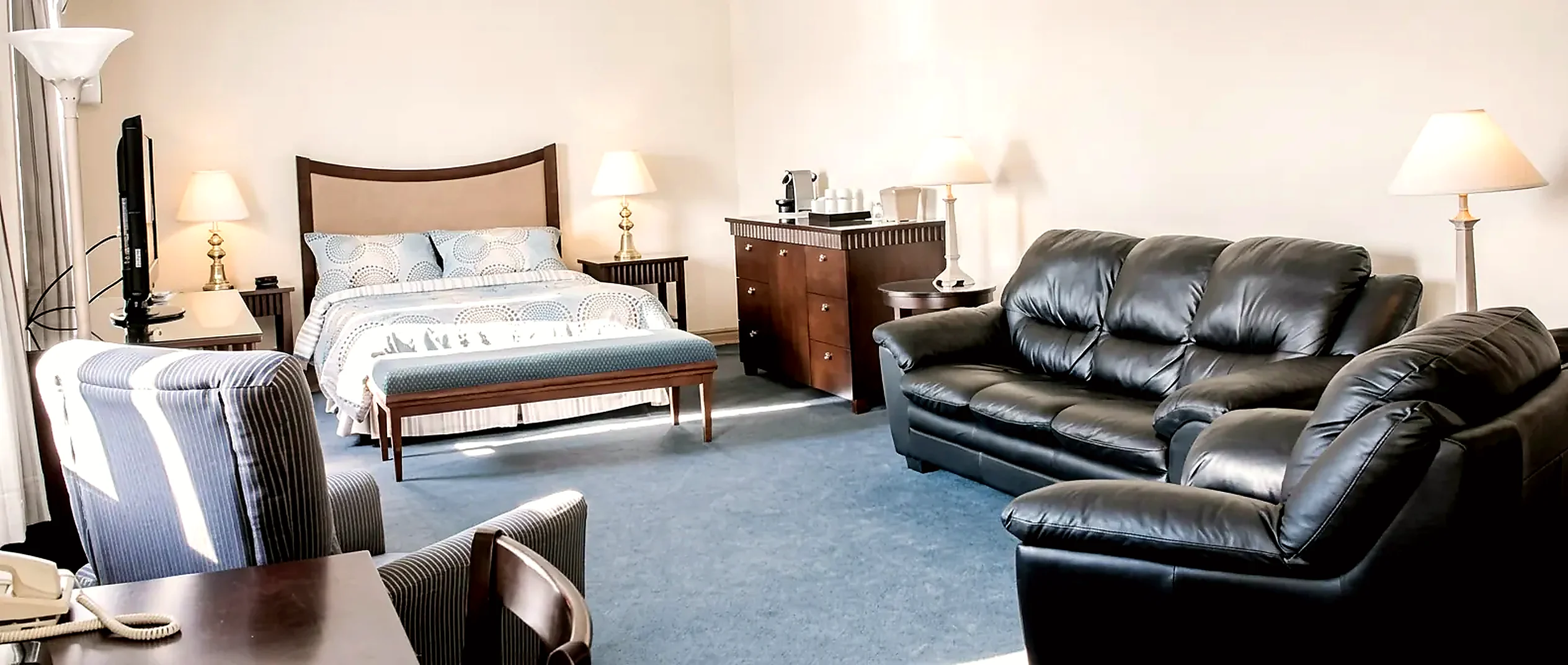 Wabush Hotel suite with a bed, sofa and dresser in a separate sitting area